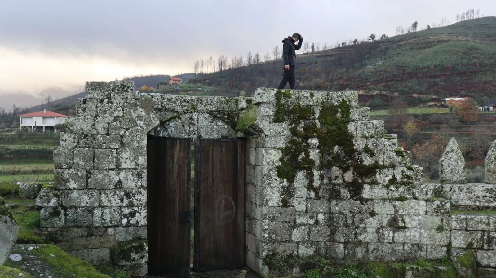 Porta de pedra antiga com montanhas ao fundo