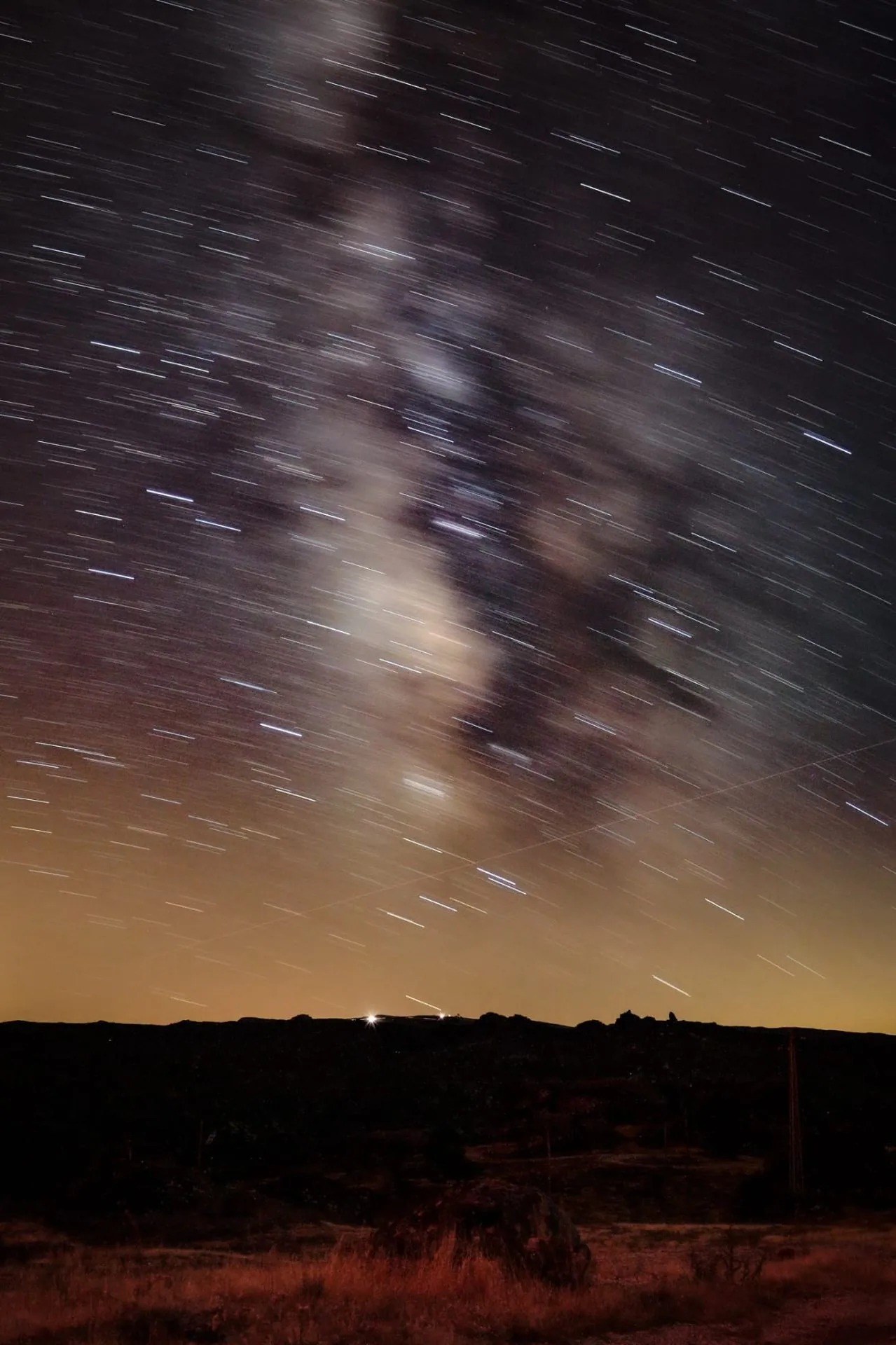 Via Láctea com star trails na linha do horizonte