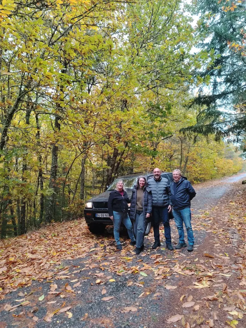 Guests next to the 100 Montanhas jeep on a track covered in autumn leaves