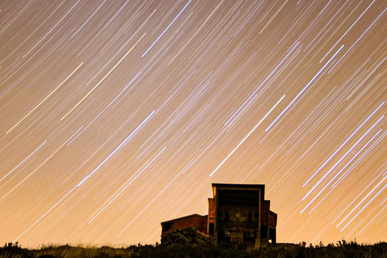 Trazos de estrellas sobre una ruina en la montaña