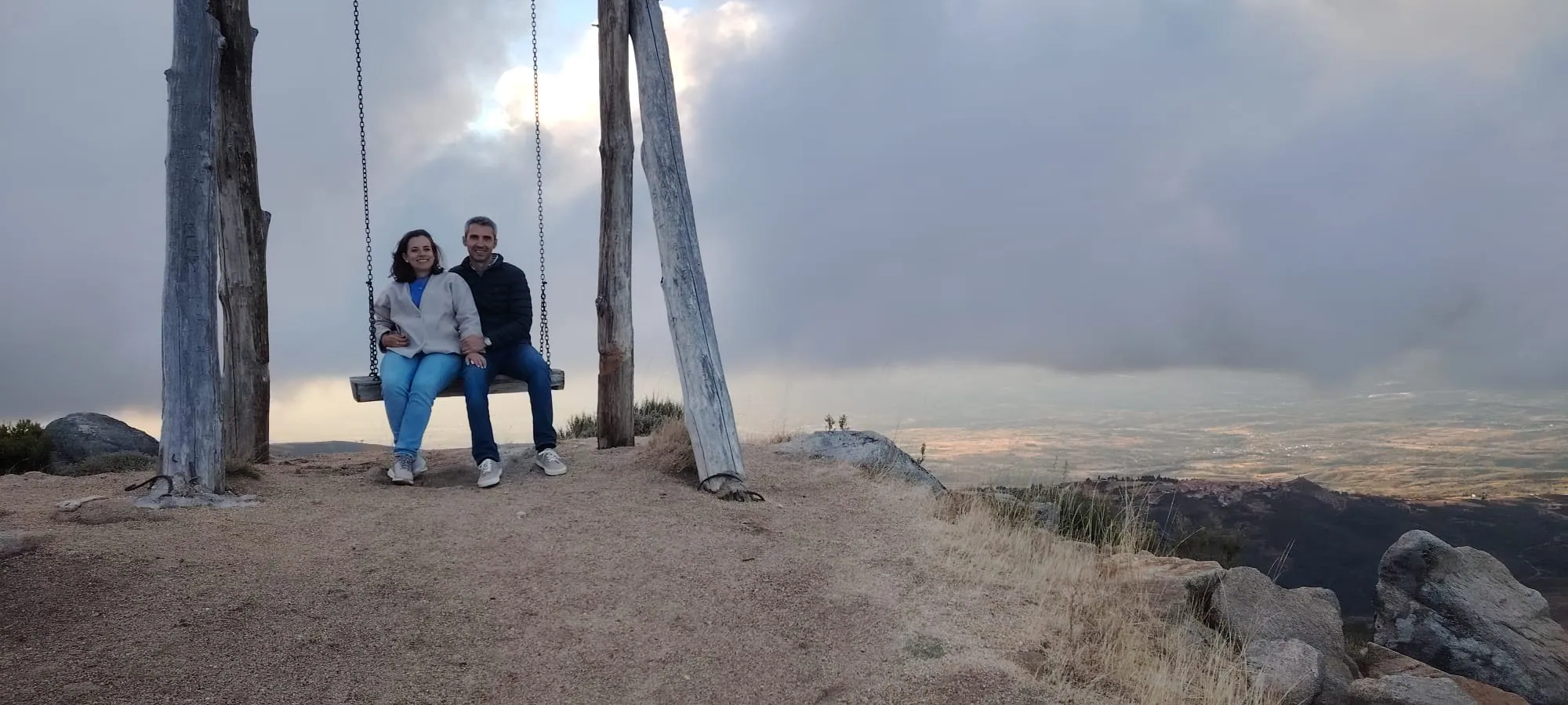 Casal a baloiçar ao pôr do sol na Serra da Estrela